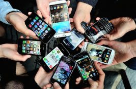 People show their smartphones on December 25, 2013 in Dinan, northwestern France.   AFP PHOTO / PHILIPPE HUGUEN